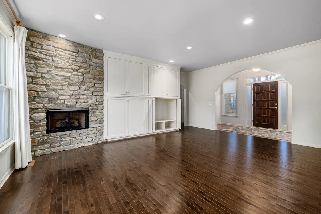 Salón antes del home staging: piso vacío con paredes blancas y suelo de parqué.